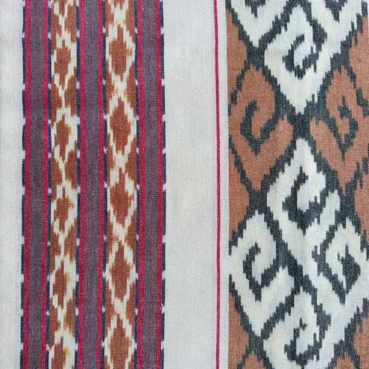Close-up of the Sunwashed Sand handwoven ikat blanket showcasing the woven stripe and geometric pattern