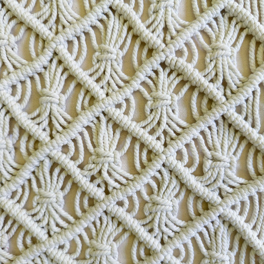 Close-up of the hand-knotted macramé diamond weave on the cushion cover
