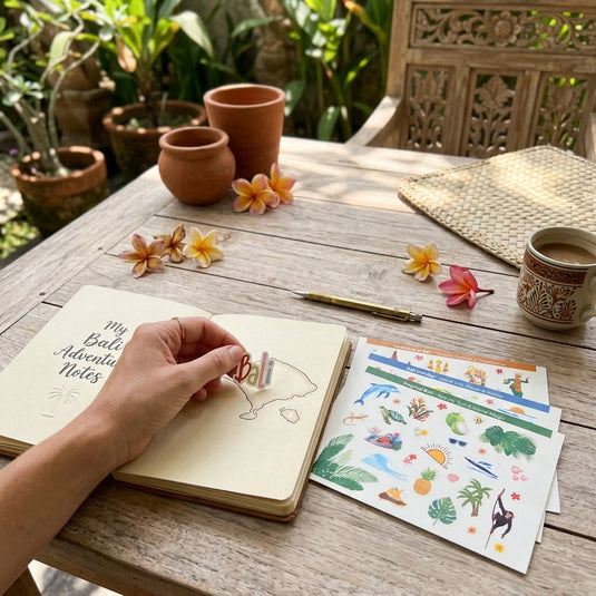 Bali sticker pack decorating a travel journal in a tropical garden setting
