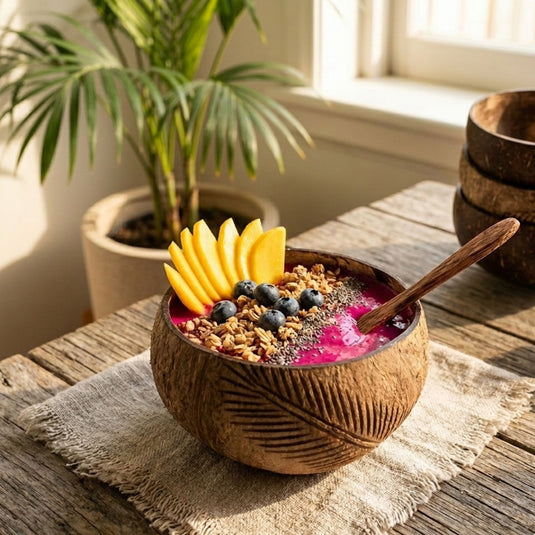 Hand-carved coconut shell bowl with palm leaf pattern used for smoothie bowl with fruit and granola